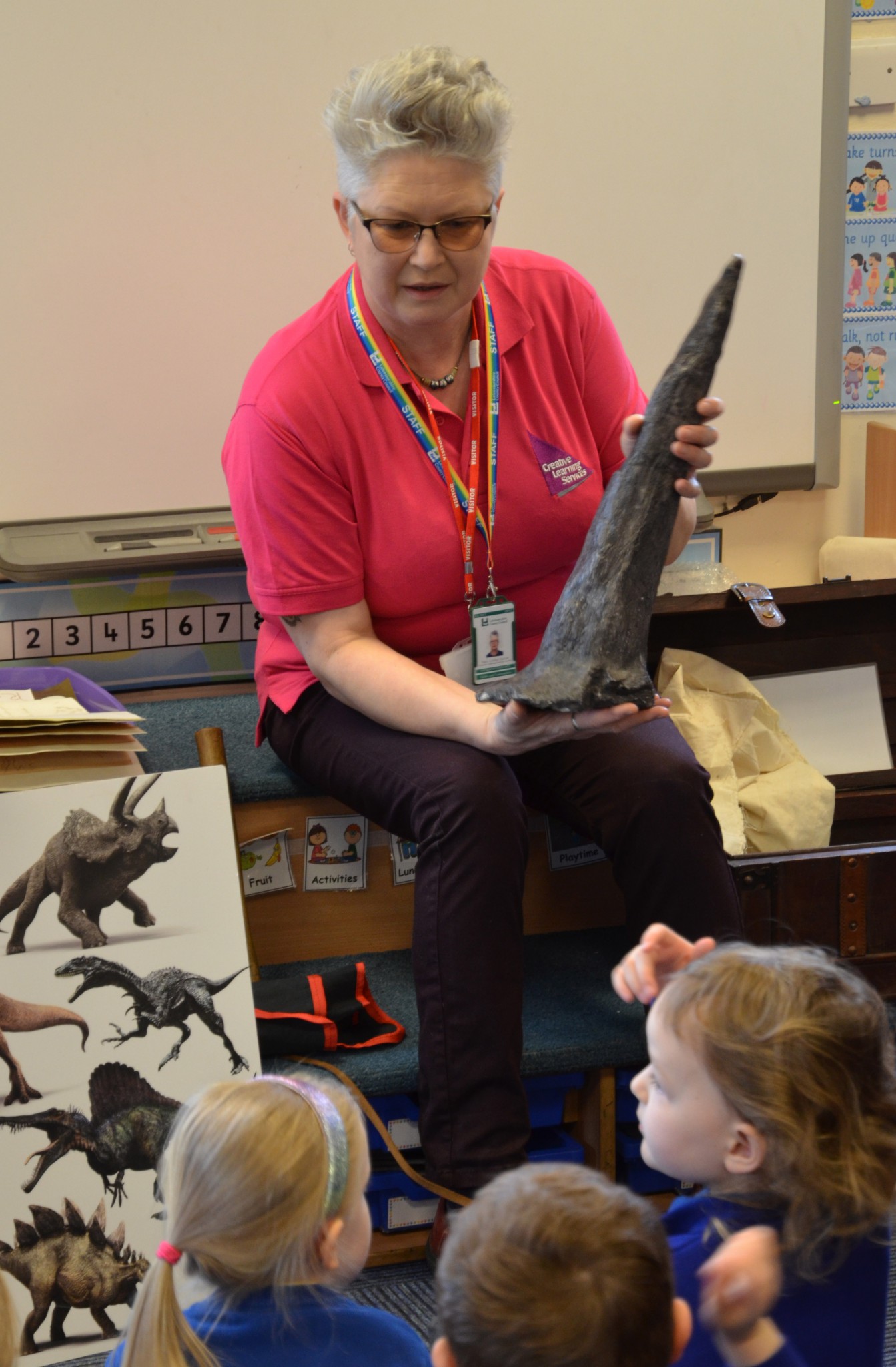 Photo of a workshop leader with a dinosaur fossil