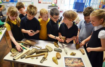 Photo of children looking at Stone Age tools