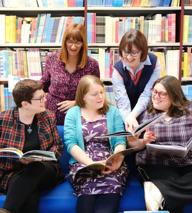 Photo of 5 librarians looking at books