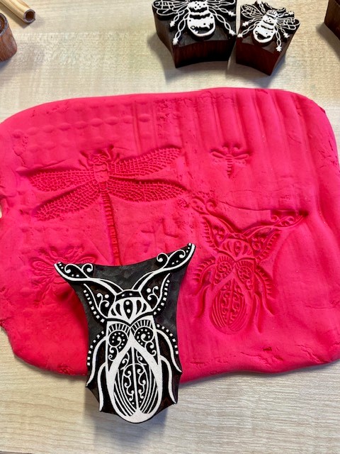 Image of red modelling clay and insect print block